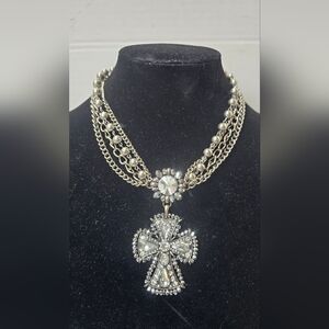 Vintage ornate silver-tone necklace features a striking crystal cross pendant